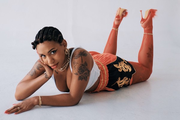 Studio portrait of Yaya Bey laying down on her stomach, gazing toward the camera.