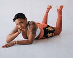 Studio portrait of Yaya Bey laying down on her stomach, gazing toward the camera.