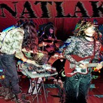 Experimental action shot of NATLAK performing on stage. Image has a double exposure effect and band name "NATLAK" is written in a vaporizing font.