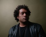 Portrait of solo artist Makaya McCraven gazing toward the camera with a neutral background.