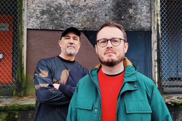 Outdoor portrait of duo CHXMERAS looking toward the camera.