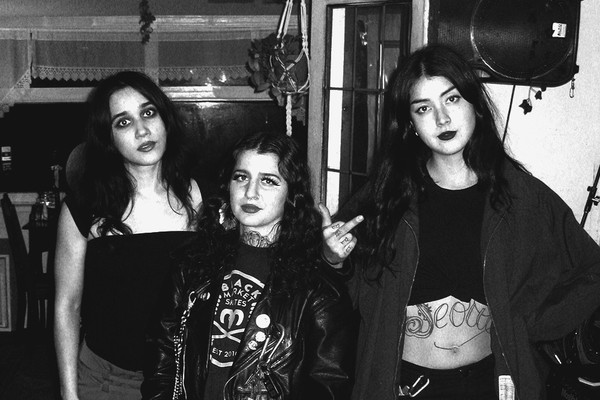 Indoor black and white portrait of trio MUÑECA standing and facing the camera