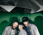 Studio portrait of trio Motherhood posed closely together with a dark mesh covering them