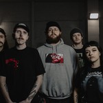 Dark, gritty portrait of five-piece Abrupt Decay standing and looking toward the camera.