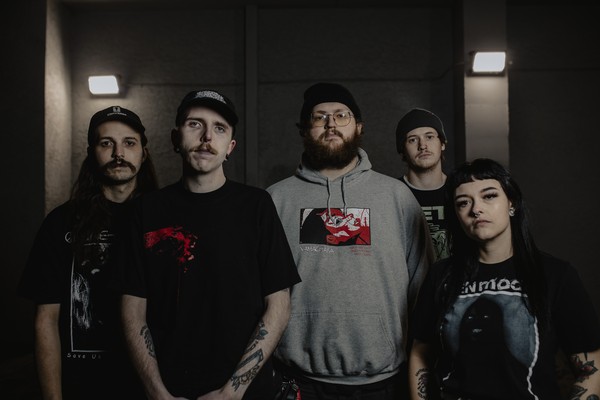Dark, gritty portrait of five-piece Abrupt Decay standing and looking toward the camera.