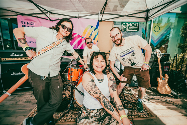 Four-piece Bad bodies are positioned on the eighty-eight patio, smiling toward the camera.