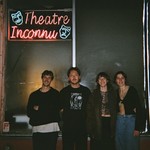 Photo taken at night, featuring four members of Blush. standing outside a window with a neon sign above which reads "Theatre Inconnu."