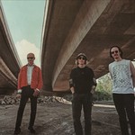 Photo of five-piece Bridgeland standing underneath a bridge by the river.