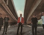 Photo of five-piece Bridgeland standing underneath a bridge by the river.