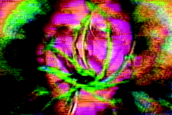 A vibrant, static-filled photo of a face, barely visible due to the high-contrast abstract effect. A green hue seems to be taking over the face, adding a surreal, unsettling touch.