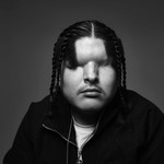 A black and white up-close portrait photo of blind trap artist Mattmac against a grey background.