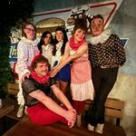 A colour photo of six-piece Parisian Orgy shows them posing on the Palomino patio dresssed in clown-like attire and light clown makeup.