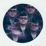 A colour kaleidoscope-type photo shows the front person of Pearly Moon from the shoulders up wearing orange glasses with flowers in the background. Because of the kaleiscope effect, there appears to be five of the same person