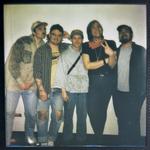 A slightly out of focus colour polaroid shows five-piece Spirit Hote smiling for a photo against a white wall.