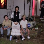 A colour photo shows three-piece band Tiger Really posing for a photo outside of a house party.