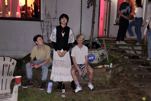 A colour photo shows three-piece band Tiger Really posing for a photo outside of a house party.