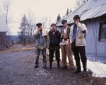 A colour photo shows four-piece group Truck Violence standing outside in front of an old building. Each member is shown smoking a cigarette. 