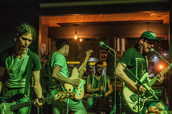 A colour photo shows four-piece band Yarbo playing at an indoor venue.