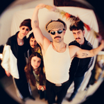 Shot with a fish eye effect, photo of five-piece Pastel Blank posed in a room, facing the camera.