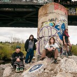 Photo taken outdoors, under a graffiti-filled bridge of five-piece Rebel Grrrlz