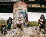 Photo taken outdoors, under a graffiti-filled bridge of five-piece Rebel Grrrlz