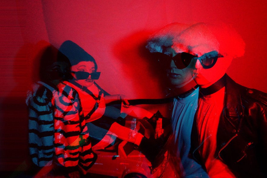 Double exposure photo washed in red light of the front person of Wheelchair Sports Camp holding someone in a leather jacket and sunglasses by the leash