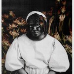 Solo artist Backxwash is photographed in black and white. Warm toned flowers fill the background.