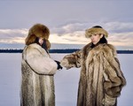Duo Cartel Madras are posed in a vast snow covered terrain, both wearing heavy fur coats and hats.