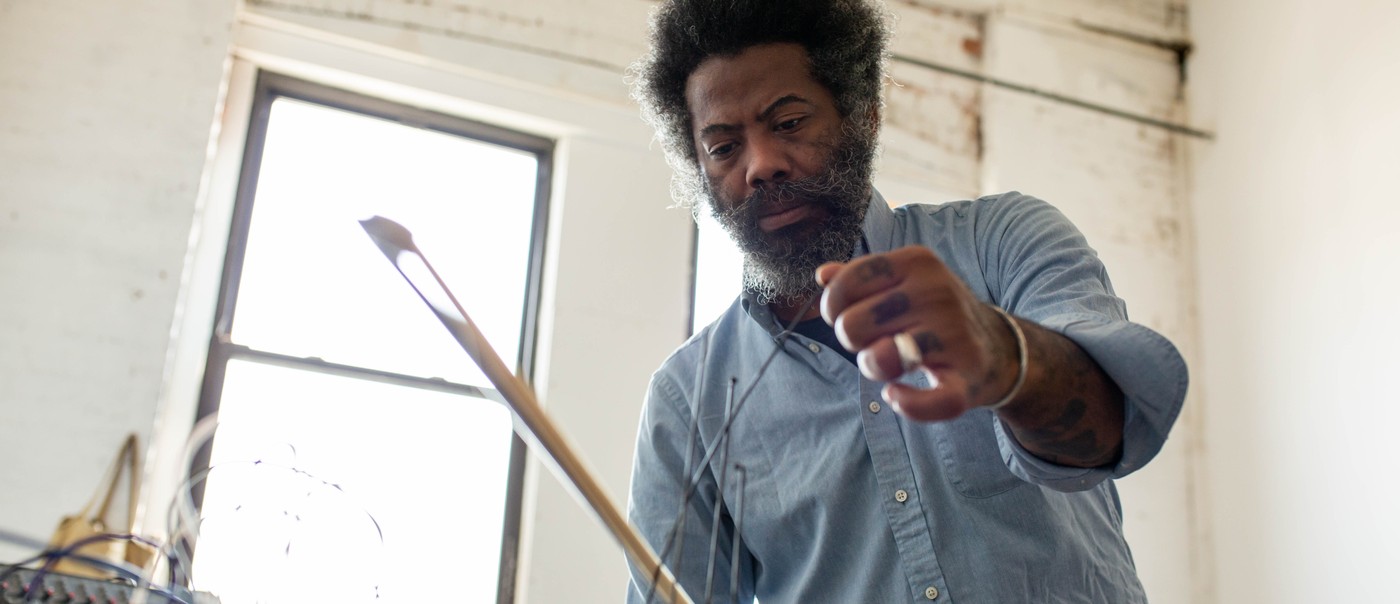 Photo of experimental artist Robert Aiki Aubrey Lowe, captured in motion.