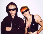 Duo Sextile are both in dark sunglasses, faced toward the camera, with a neutral background