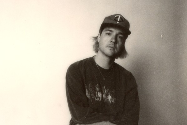 Photo taken of solo artist HOMESHAKE posed seated in a chair, wearing a baseball cap