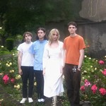 Photo of four-piece feeble little horse, posed standing in front of a bed of flowers