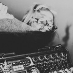 Experimental performer Granpa (Lucas Abela) is holding a large piece of glass pressed against his lips, with a modular synthesizer in frame.