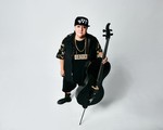 Photo shot from above of Chris Derksen holding a cello, looking up toward the camera.