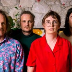 A vibrant colour photo of four-piece Bananahaus standing in front of a stone wall.