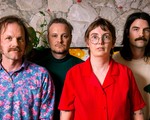 A vibrant colour photo of four-piece Bananahaus standing in front of a stone wall.