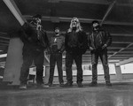 A black and white photo shows four-piece band Culled standing in large concrete parkade.