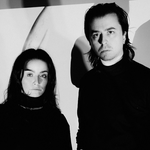 A black and white photo shows duo Dermabrasion standing in a white room wearing all black.
