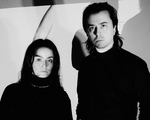 A black and white photo shows duo Dermabrasion standing in a white room wearing all black.