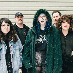 A colour photo shows five-piece group Midnight Peg standing outdoors on a winter day