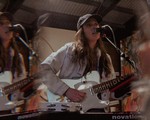 A double exposure photo shows frontperson of the project mon cher playing a white electric guitar and singing into a microphone. 