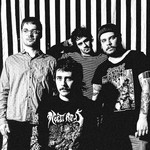 A fuzzy black and white photo shows four-piece Pnoom posing in front of a black and white striped wall. 