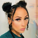 A double exposure photo shows a artist Tinywiings with a close-up on their face, with a faded copy of their face above on the the top right. Their hair is in two tight buns on the top of their head, with two braids hanging down each side. 